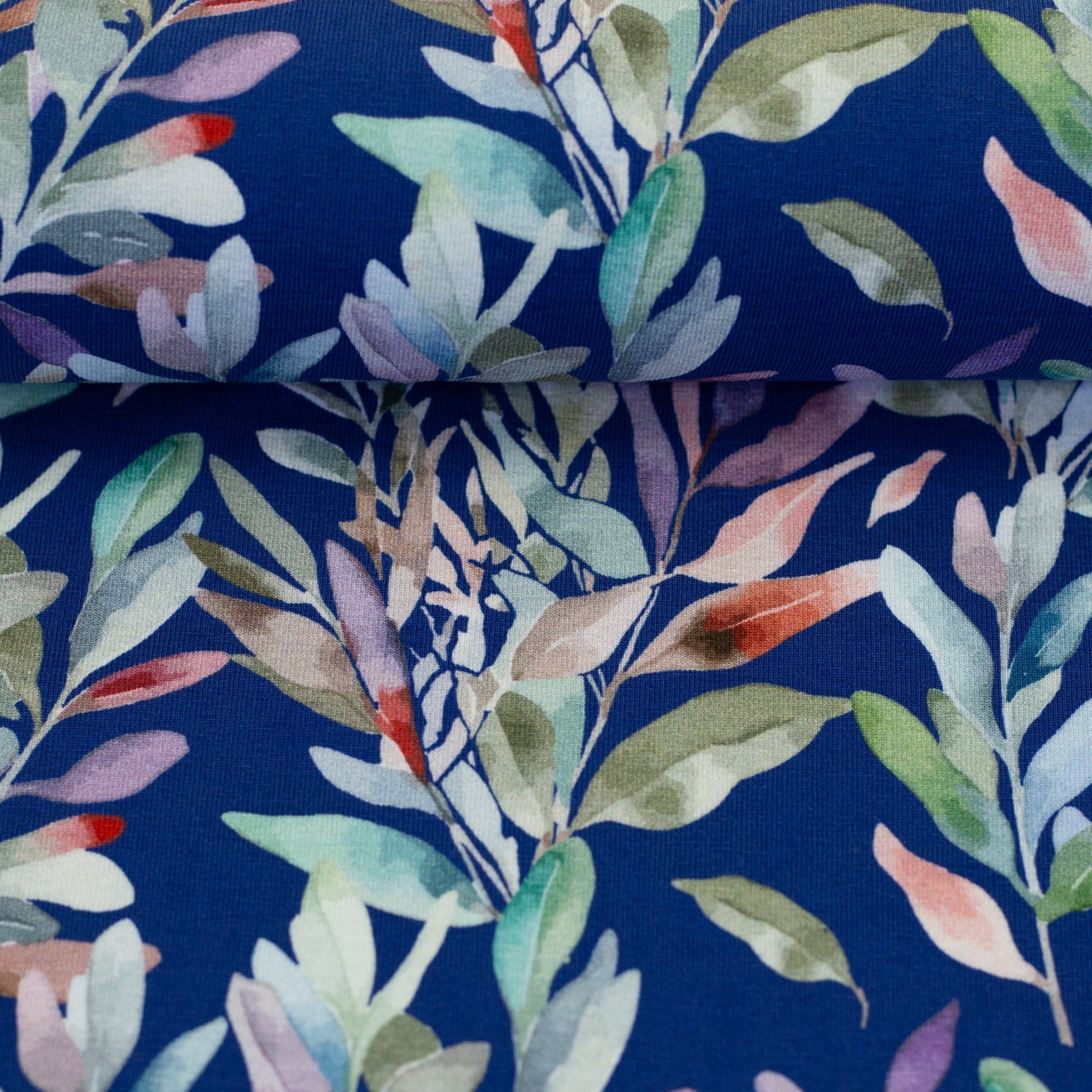 Kokvilnas trikotāža - lapas uz zila fona 200 g/m²