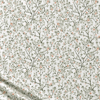 Image of 100% cotton fabric with delicate green branches and flowers on a white background – available online at Šarlotes audumi