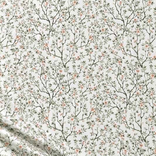Image of 100% cotton fabric with delicate green branches and flowers on a white background – available online at Šarlotes audumi