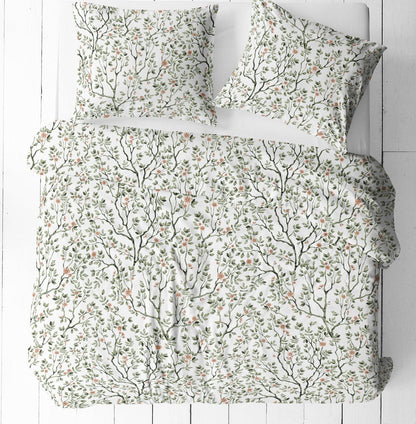 Image of 100% cotton fabric with delicate green branches and flowers on a white background – available online at Šarlotes audumi