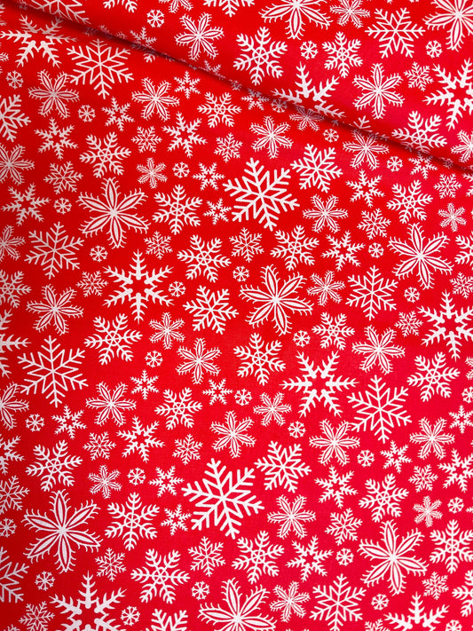 Attēls ar 100% Kokvilnas audums - sniegpārslas uz sarkana fona 125 g/m – pieejams Šarlotes audumi