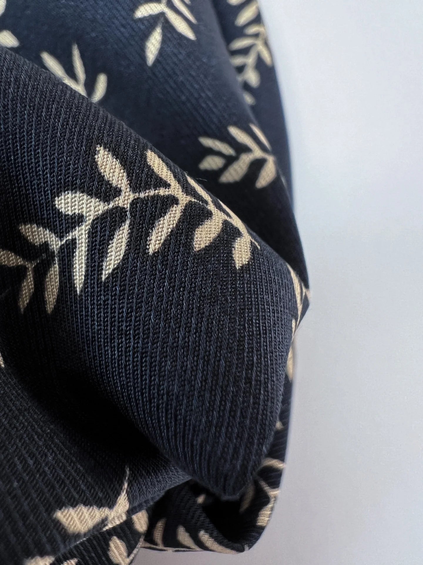 Attēls ar 100% Viskozes audums - bēšas lapiņas uz tumši zila 96 g/m² – pieejams Šarlotes audumi