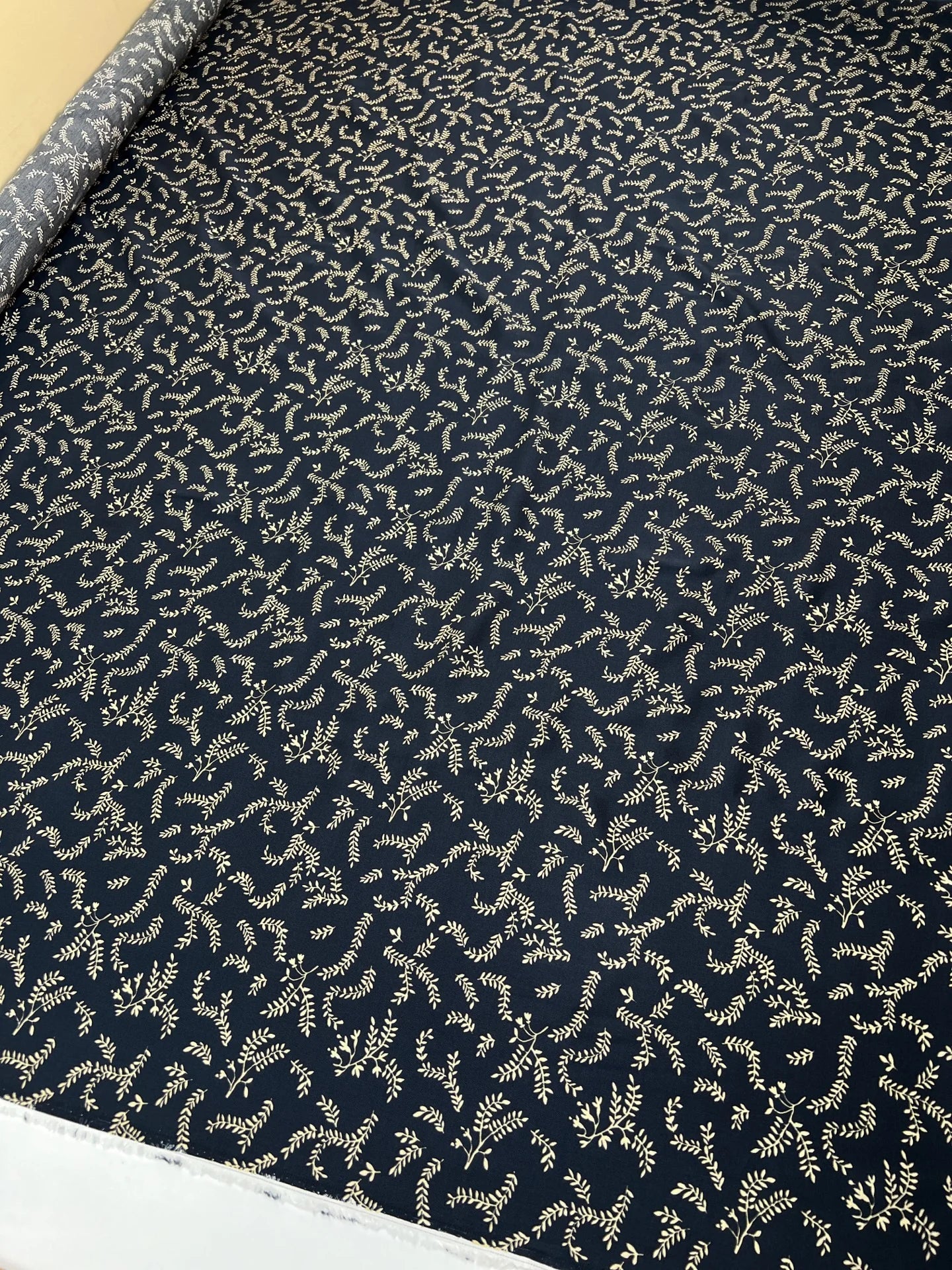 Attēls ar 100% Viskozes audums - bēšas lapiņas uz tumši zila 96 g/m² – pieejams Šarlotes audumi