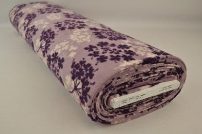 Image of fleece fabric with a tree pattern – purple/beige – available online at Charlotte's Fabrics