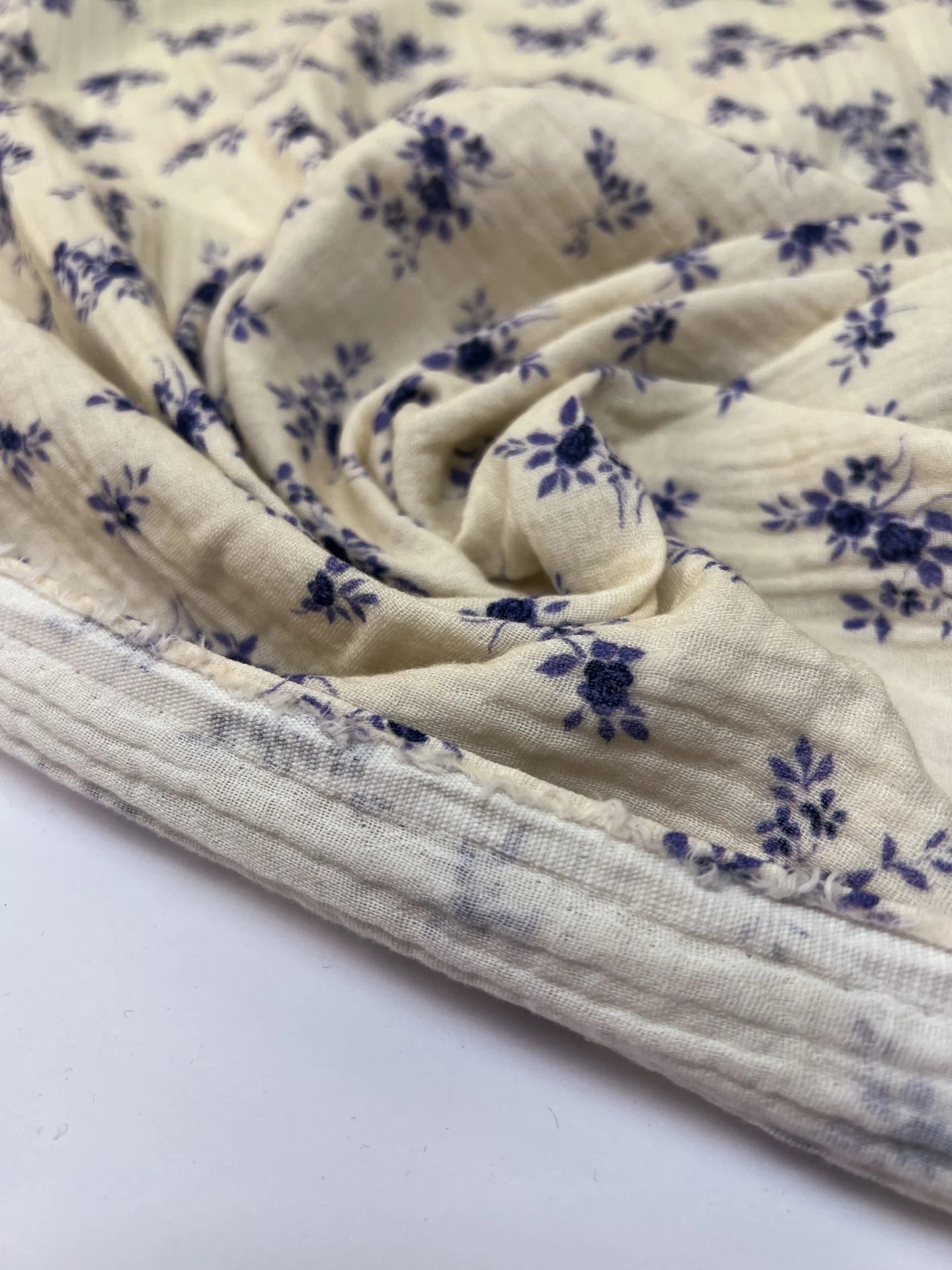 Attēls ar Francijas kokvilnas muslīna audums – balts ar ziliem ziediem | 100% kokvilna | 160 g/m² | 145 cm – pieejams Šarlotes audumi