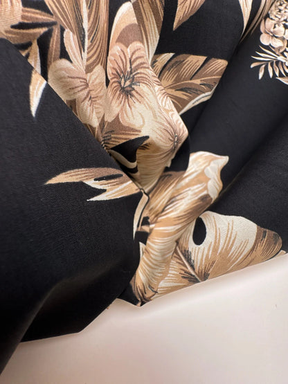Image of Italian cotton fabric with a tropical floral pattern on a black background – available online at Charlotte's Fabrics