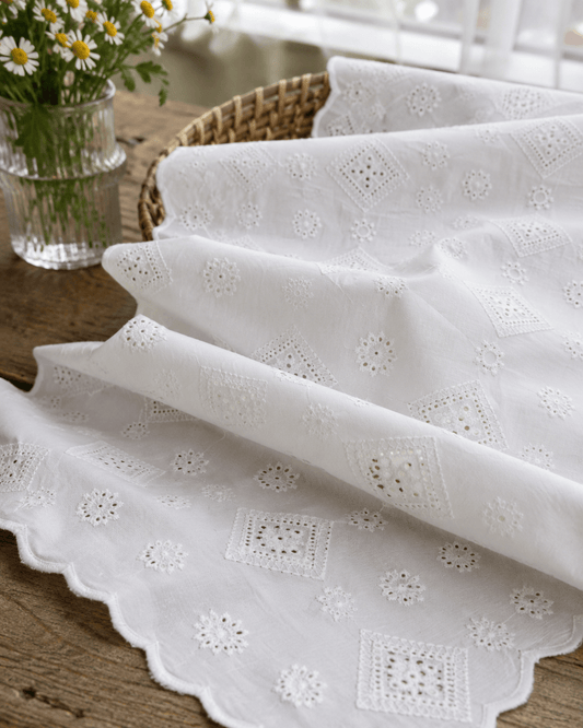 Embroidered cotton fabric with diamond and floral motif in white, 150 g/m² – available online at Šarlotes audumi