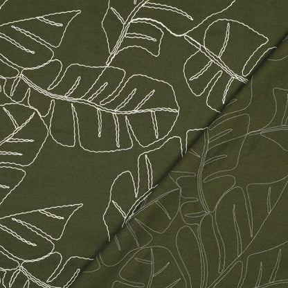 Image of linen with viscose-embroidered leaves on a green background, 210 g/m² – available at Charlotte's Fabrics
