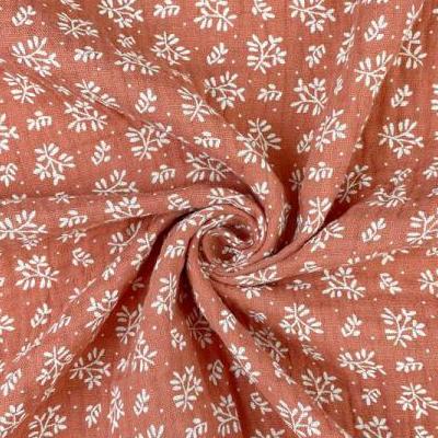Muslin - white flowers on an orange background 130 g/m²