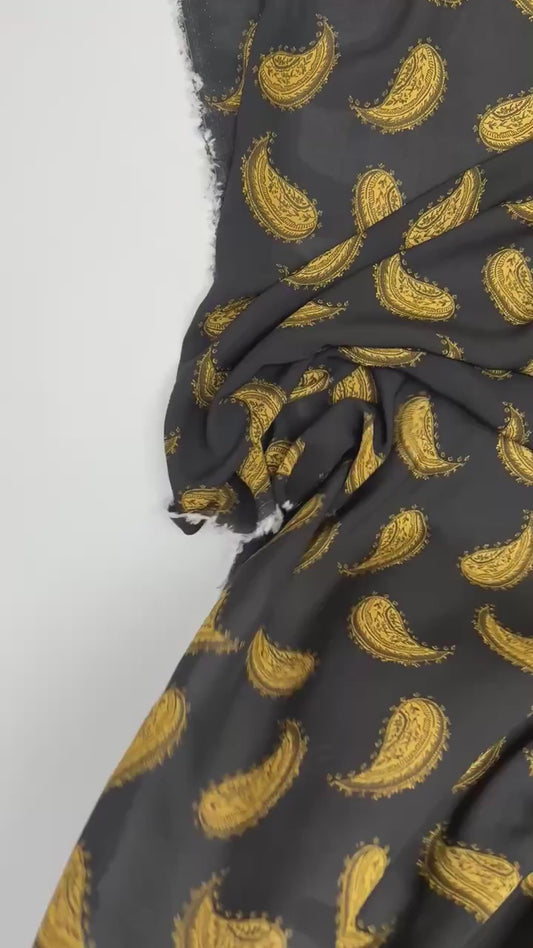 Italian 100% viscose chiffon fabric with golden paisley pattern on a black background – 100 g/m²
