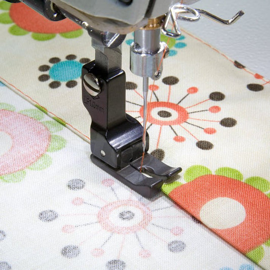 Image d’un pied-de-biche compensateur gauche pour machine à coudre industrielle, 1,0 mm avec revêtement PTFE – disponible chez les tissus Charlotte